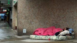 Homeless man and woman sleep on the sidewalk in Buenos Aires